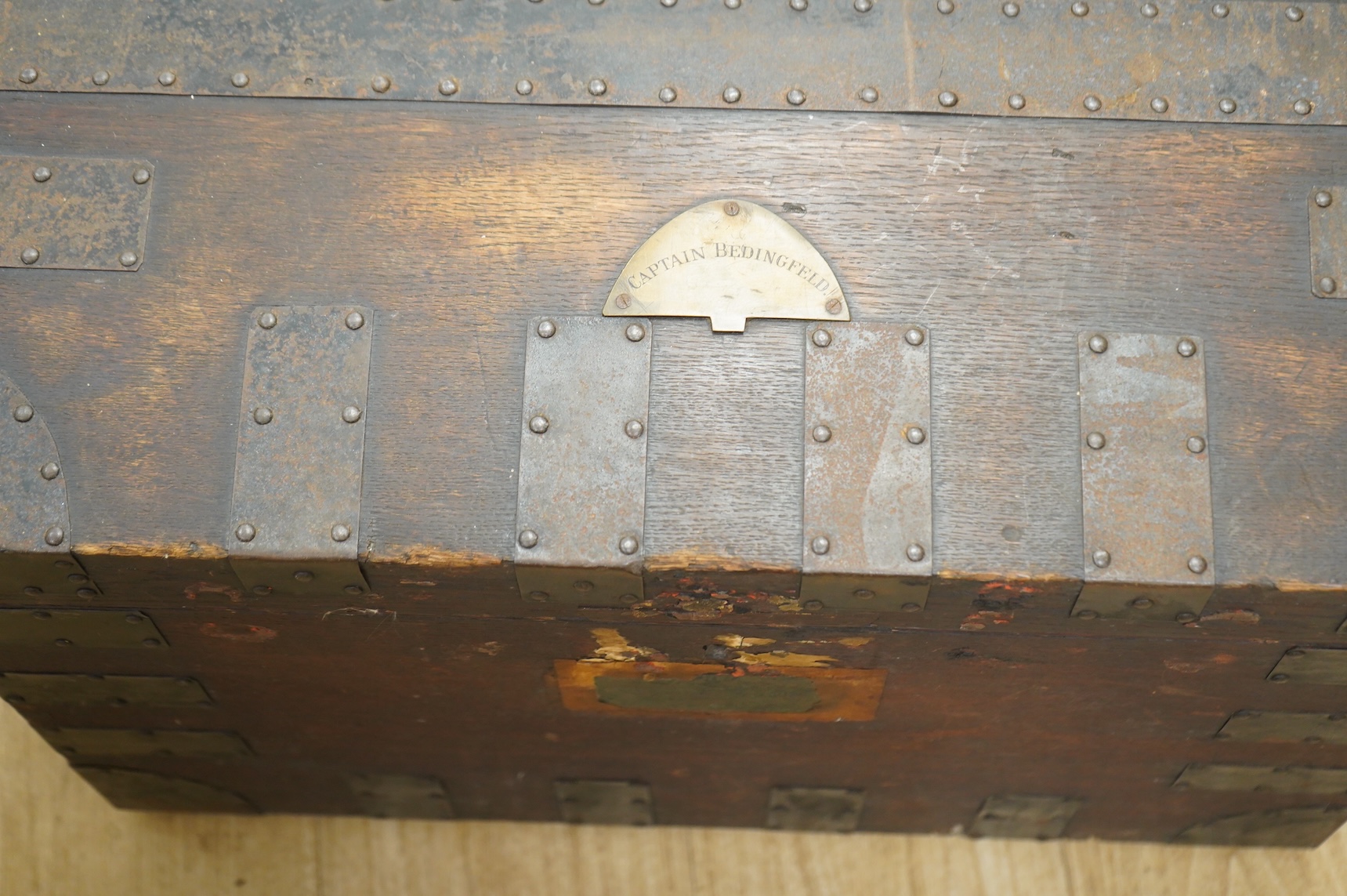 A iron bound oak chest with a fitted interior and removable trays to house an extensive dining set, owned by Captain Norman Bedingfield R.N., with an applied brass plaque to the lid engraved ‘Captain Bedingfield’, togeth